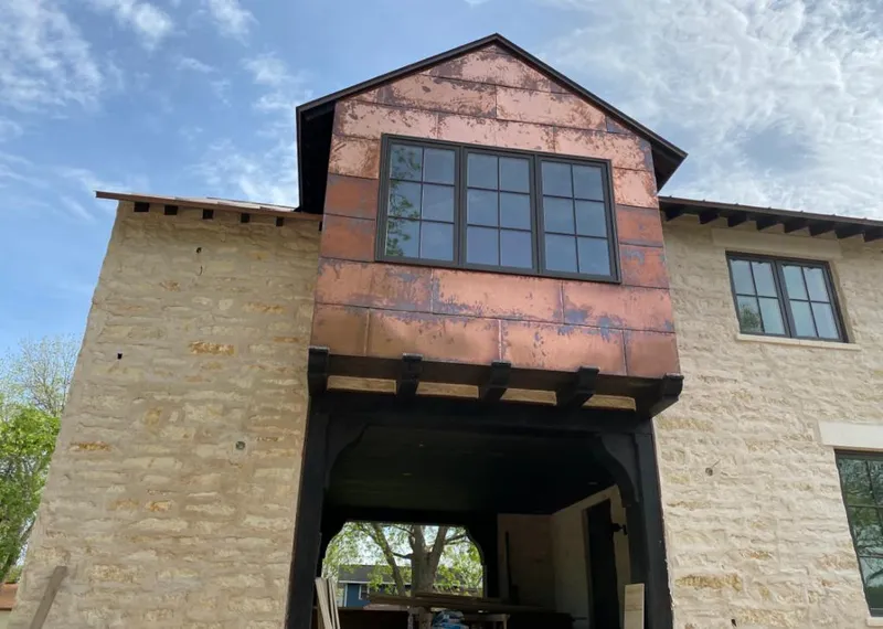 Copper metal panel facade on a stone building for Skylight Installation in Hilmar-Irwin